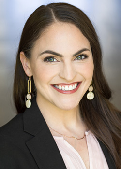 Woman in suit with grey background. Kris Lindsey Hall headshot
