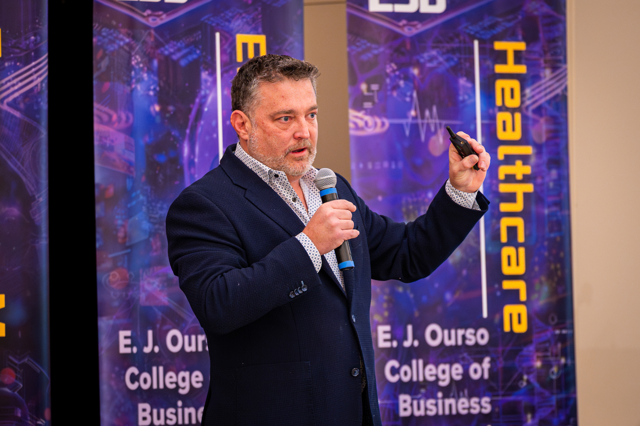 Darren Haas holds a microphone while speaking on stage