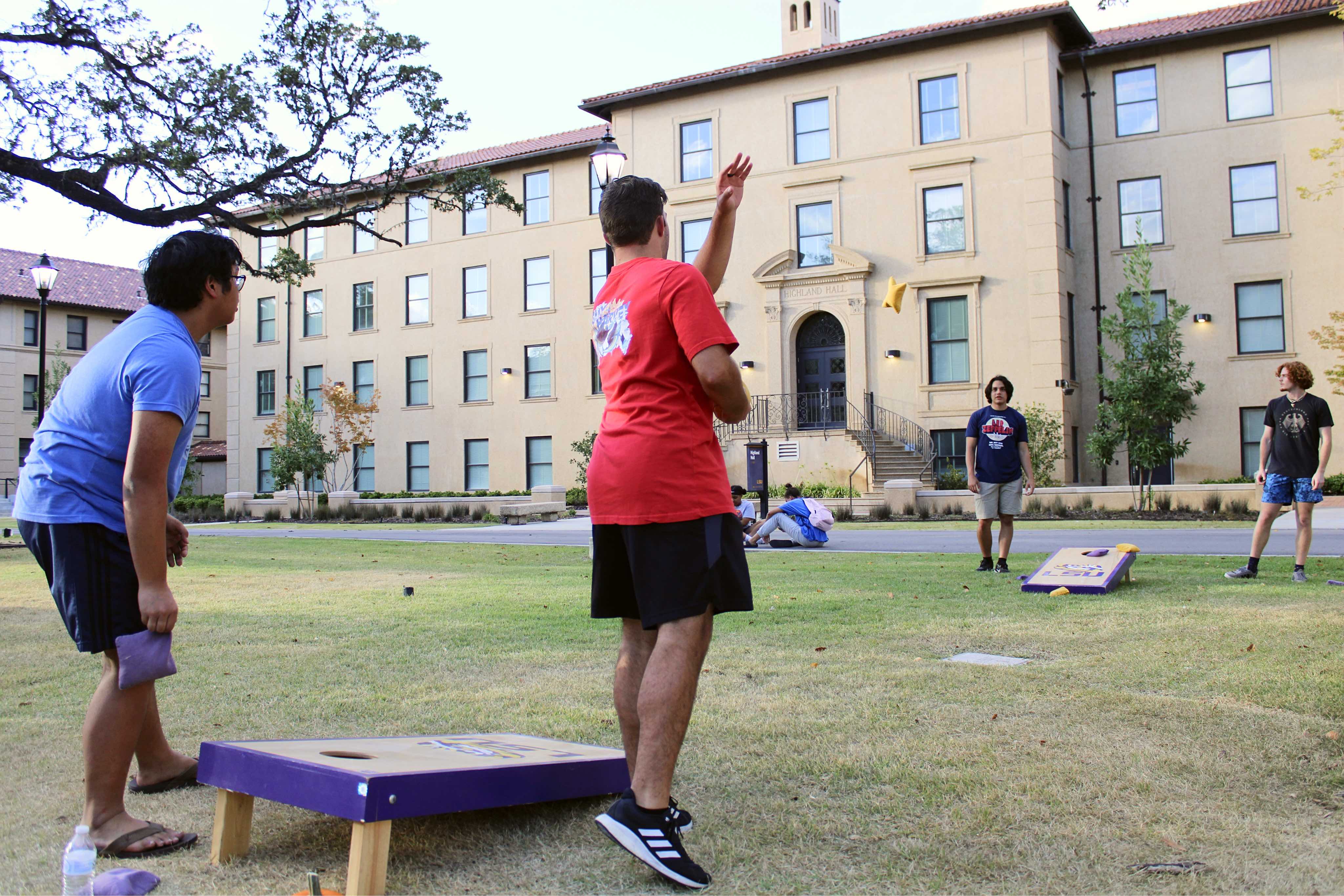 Residents playing cornhole in the courtyard of the Horseshoe Community.