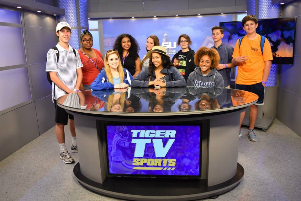 High school students sitting behind TigerTV desk