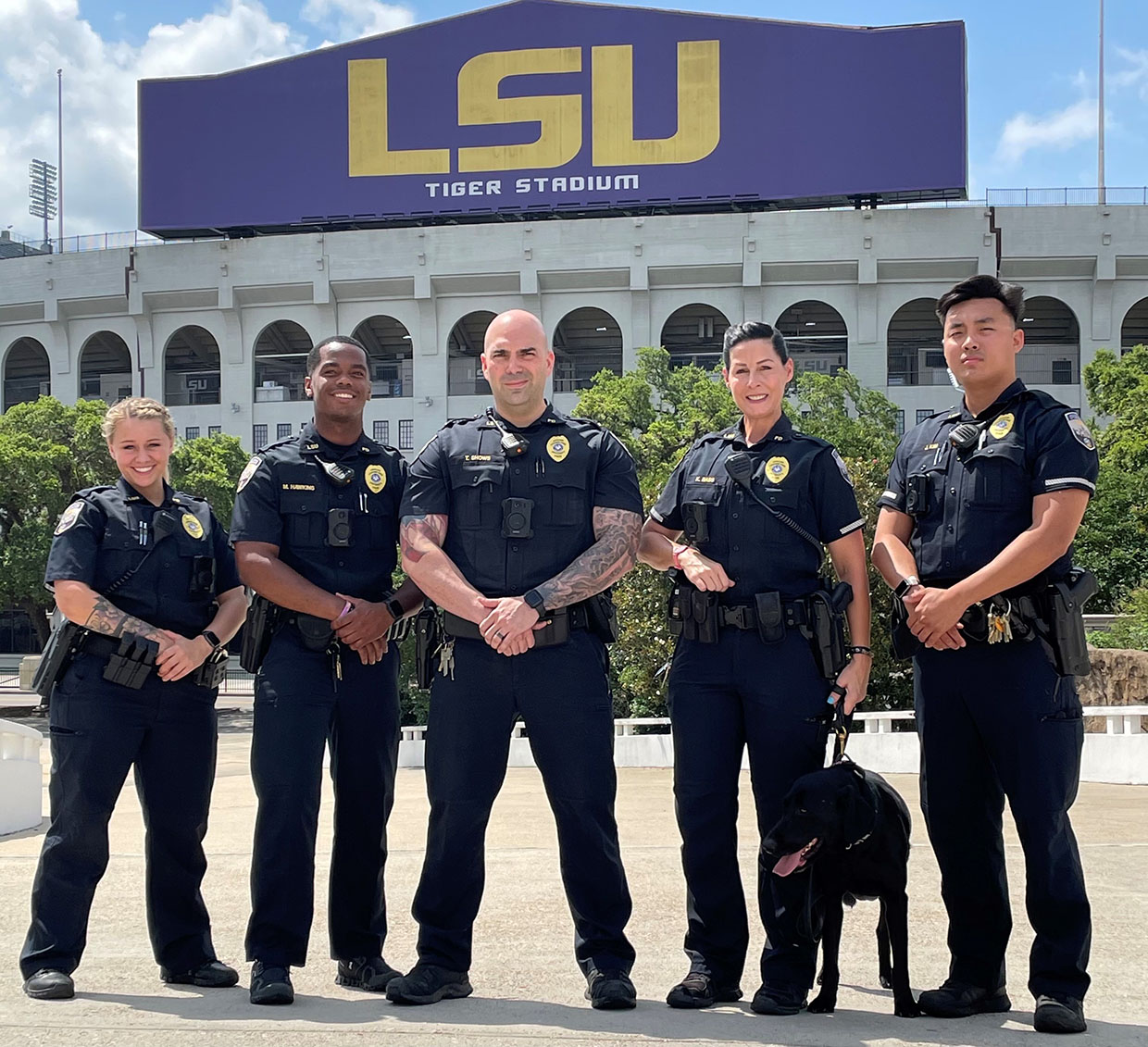 LSU Police officers and police dog, Tiger Stadium in background.