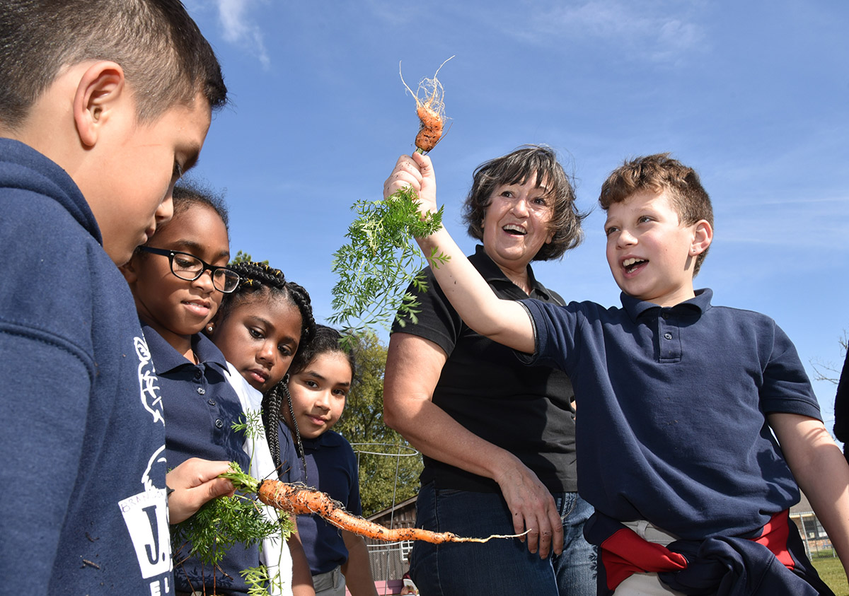 Denise Mayon and children at the J.S. Aucoin Elementary School in Amelia, Louisiana, show off carrots they harvested in the school garden.